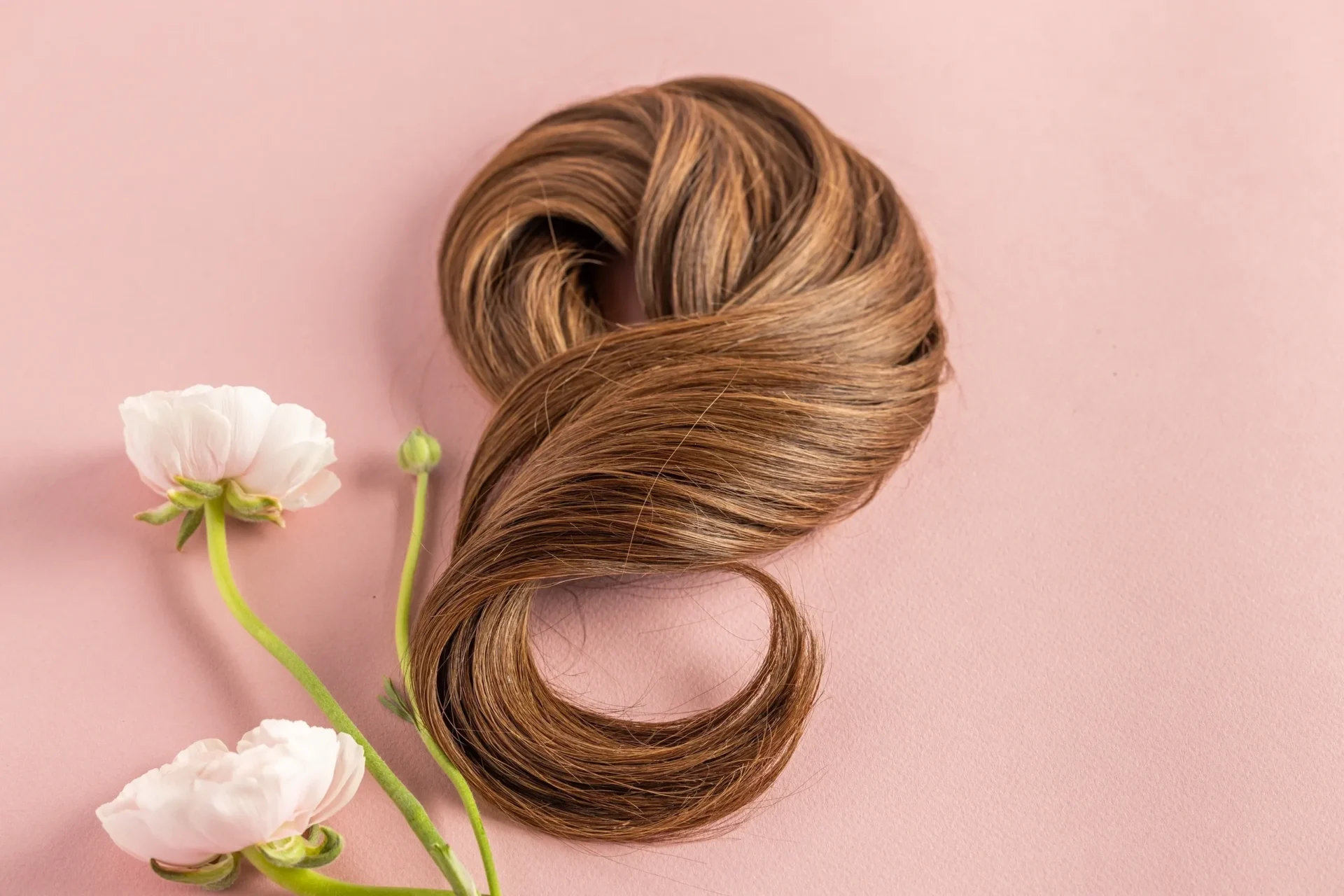 A hair piece sitting next to some flowers